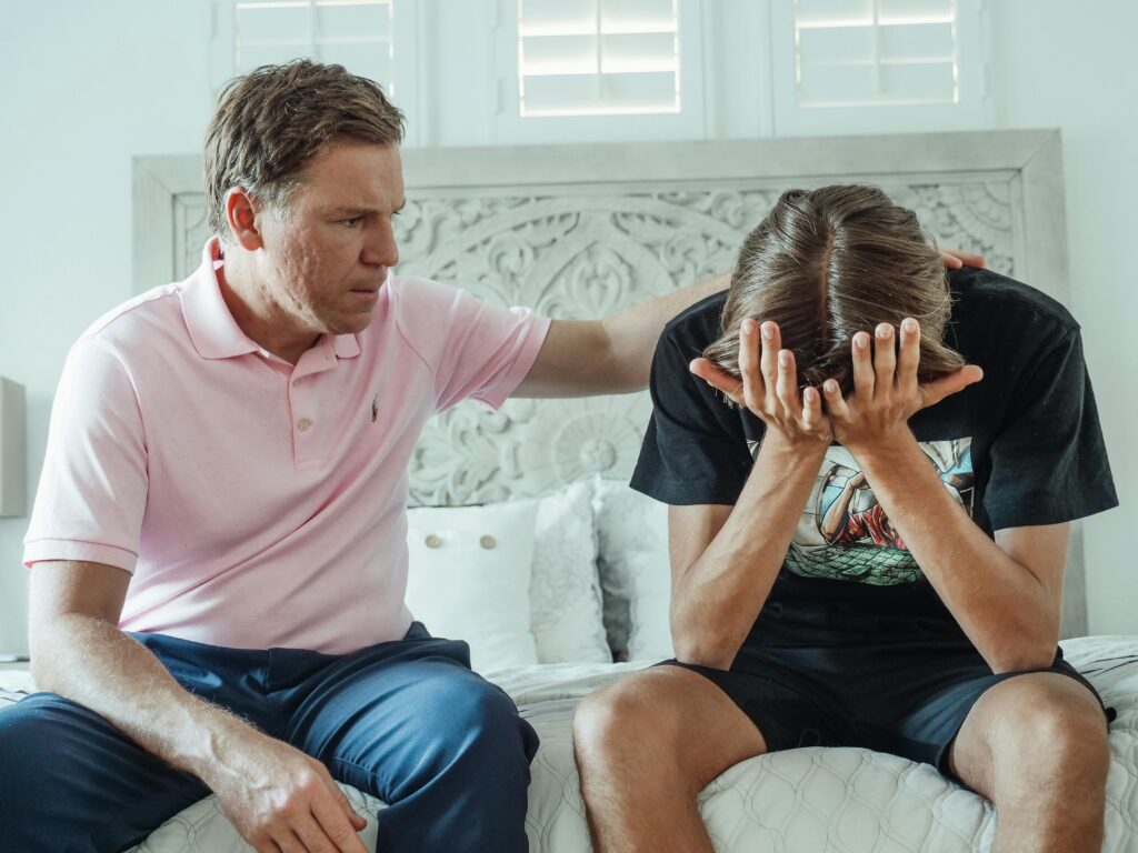 pexels photo 8550682 8550682 A compassionate father consoles his upset teenage son on a bed indoors.